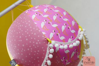 Ein Adventskalender Adventsballon mit Flamingos für meine Tochter. Nähanleitung und Schnittmuster gestaltet als PDF-E-Book von shesmile für einen Adventskalender und Kinderzimmerdeko Adventsballon in Form eines Heißluftballons. 24 kleine Geschenke oder ein Musikwürfel finden ihren Platz an den Halteschlaufen am oder im Körbchen.