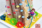 Kletterwand-Kuchen zum Kindergeburtstag mit Smarties, Gummibärchen-Seilen und Playmobil-Figur
